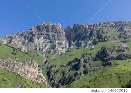 Mountain landscape near Dzheyrakh village with rocky cliffs and green slopes Mountain landscape near Dzheyrakh village with rocky cliffs and green slopes 140217613