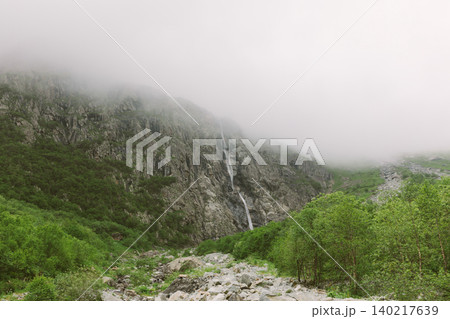 Misty Midagrabin waterfalls cascading down rocky mountain gorge in summer 140217639