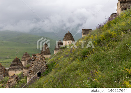 Dargavs City of the Dead necropolis tombs on misty Caucasus mountain slope 140217644