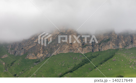 Foggy rocky cliffs above green hills in Aktoprak mountain valley landscape Foggy rocky cliffs above green hills in Aktoprak mountain valley landscape 140217649