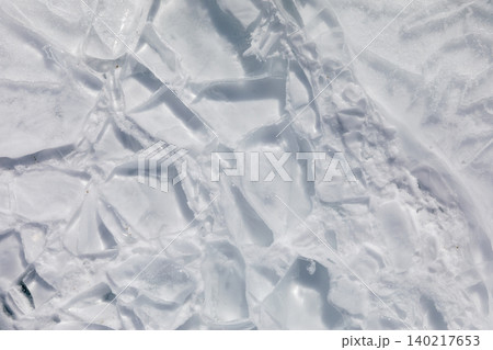 Cracked ice texture on Lake Baikal in winter, natural frozen water background Cracked ice texture on Lake Baikal in winter, natural frozen water background 140217653