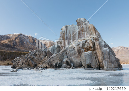 Rocky cliff and frozen shoreline on Lake Baikal under clear winter sky Rocky cliff and frozen shoreline on Lake Baikal under clear winter sky 140217659