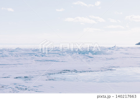 Frozen Lake Baikal winter landscape with blue ice hummocks under pale sky Frozen Lake Baikal winter landscape with blue ice hummocks under pale sky 140217663