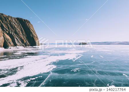 Frozen Lake Baikal shoreline with cliffs, ice cracks and winter landscape Frozen Lake Baikal shoreline with cliffs, ice cracks and winter landscape 140217764