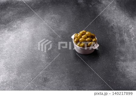 Whole green olives without pits in a bowl as an ingredient for cooking at home. Green olives Whole green olives without pits in a bowl as an ingredient for cooking at home. Green olives 140217899
