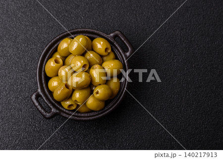 Whole green olives without pits in a bowl as an ingredient for cooking at home. Green olives Whole green olives without pits in a bowl as an ingredient for cooking at home. Green olives 140217913
