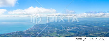 Sweeping mountain panorama revealing the sparkling Mediterranean Sea, Estepona and distant Gibraltar beneath open skies from Sierra Bermeja in Spain. Sweeping mountain panorama revealing the sparkling Mediterranean Sea, Estepona and distant Gibraltar beneath open skies from Sierra Bermeja in Spain. 140217970