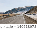 Empty highway through Tazheran Steppe with snowy hills near Lake Baikal 140218078