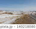Winter road through Tazheran steppe with snow fields and distant hills panorama 140218080