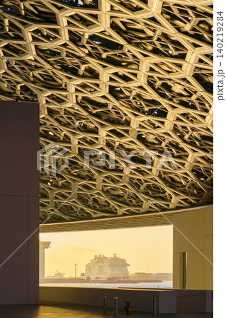 Abu Dhabi, United Arab Emirates - Jan 17 2024, Panoramic view of port with moored cruise ship MSC Viruosa, from the Louvre Abu Dhabi with dome on top, at sunset, Abu Dhabi, United Arab Emirates Abu Dhabi, United Arab Emirates - Jan 17 2024, Panoramic view of port with moored cruise ship MSC Viruosa, from the Louvre Abu Dhabi with dome on top, at sunset, Abu Dhabi, United Arab Emirates 140219284