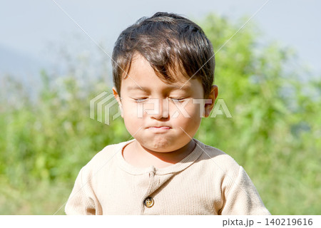 A cute toddler boy walking in a park with a blurred natural background	 140219616