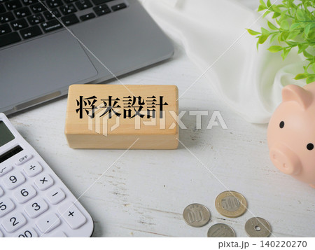 将来設計の木製ブロックと貯金箱・電卓による資産形成のイメージ 140220270