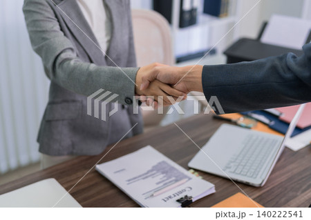 business professionals handshake agreement partnership meeting office desk with contract documents laptop modern corporate workspace collaboration success business professionals handshake agreement partnership meeting office desk with contract documents laptop modern corporate workspace collaboration success 140222541
