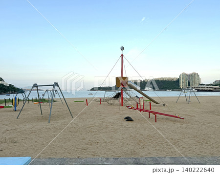Beach playground with swings and slides overlooking the ocean and city skyline Beach playground with swings and slides overlooking the ocean and city skyline 140222640