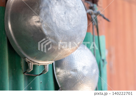 Old aluminum cookware hanging rustic wall featuring traditional kitchen utensils household equipment everyday domestic life details 140222701