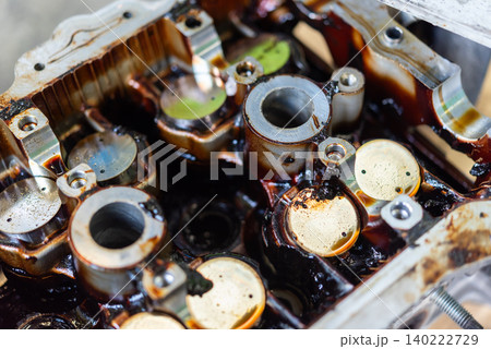Closeup of an engine cylinder head during maintenance showing mechanical components coated engine oil Automotive repair inspection servicing process Closeup of an engine cylinder head during maintenance showing mechanical components coated engine oil Automotive repair inspection servicing process 140222729