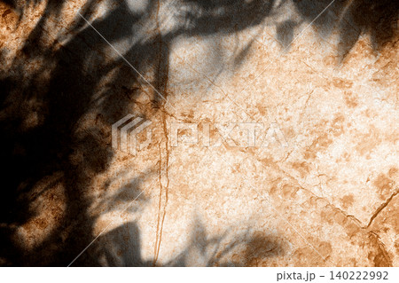 Top View Minimalist Product Backdrop with Natural Leaf Shadows on Warm Beige Concrete Texture 140222992