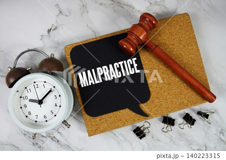 Malpractice text on speech bubble with alarm clock and wooden gavel on marble background Malpractice text on speech bubble with alarm clock and wooden gavel on marble background 140223315