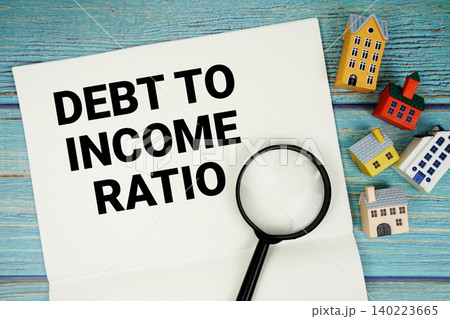 Notepad with "DTI Debt-to-income Ratio" with magnifying glass and house model on wooden background 140223665