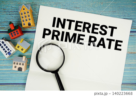 Notepad with "Interest Prime Rate" with magnifying glass and house model on wooden background Notepad with "Interest Prime Rate" with magnifying glass and house model on wooden background 140223668