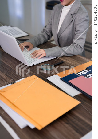 professional lawyer woman working laptop computer reviewing legal documents paperwork files folders colorful envelopes desk modern office workspace attorney professional lawyer woman working laptop computer reviewing legal documents paperwork files folders colorful envelopes desk modern office workspace attorney 140224001