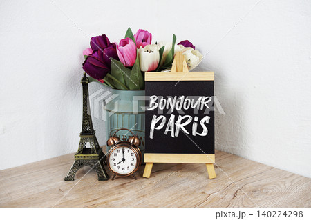 Bonjour Paris text written on easel with eiffel and alarm clock on wooden background Bonjour Paris text written on easel with eiffel and alarm clock on wooden background 140224298