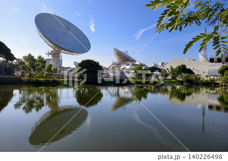 Satellite dish antenna station with reflection on pond and blue sky, Bangkok 140226498