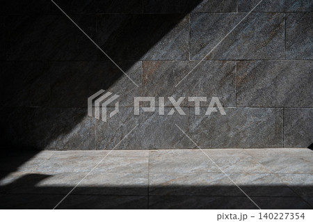 Minimalist architectural background with dramatic light and shadow contrast on marble texture. Empty dark and light stone wall mockup space on a bright sunny day. Minimalist architectural background with dramatic light and shadow contrast on marble texture. Empty dark and light stone wall mockup space on a bright sunny day. 140227354