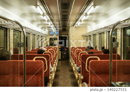 ワンマン列車の暖色系ボックスシートが並ぶ車内風景と乗客の様子 ワンマン列車の暖色系ボックスシートが並ぶ車内風景と乗客の様子 140227531