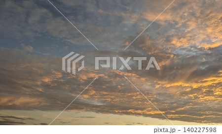 Wide scenic view captures textured altocumulus cloud layers at dawn. Vivid golden orange sunrise light illuminates dark sky details, creating a beautiful natural backdrop layout template. Wide scenic view captures textured altocumulus cloud layers at dawn. Vivid golden orange sunrise light illuminates dark sky details, creating a beautiful natural backdrop layout template. 140227598