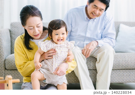 リビングで遊ぶ子供と家族 乳幼児 祖母 祖父 リビングで遊ぶ子供と家族 乳幼児 祖母 祖父 140228034