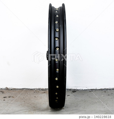 Black motorcycle wheel rim side view isolated on white background with silver spoke nipple and metal hub for motorbike custom tuning and repair part Black motorcycle wheel rim side view isolated on white background with silver spoke nipple and metal hub for motorbike custom tuning and repair part 140228618