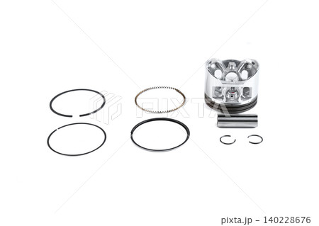 Motorcycle engine piston assembly rebuild kit with rings and pin on white top view. Motorcycle engine piston assembly rebuild kit with rings and pin on white top view. 140228676