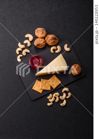 Aged cheese in a triangular block with jam, figs, and nuts. Aged cheese Aged cheese in a triangular block with jam, figs, and nuts. Aged cheese 140228953