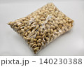 Transparent plastic bag with salted pistachios closeup on white. 140230388
