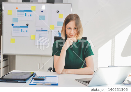 Concept of business working, Businesswoman sitting while writing and checking business analytic document report and holding tablet with computer pc, smartphone on desk in her workstation. Concept of business working, Businesswoman sitting while writing and checking business analytic document report and holding tablet with computer pc, smartphone on desk in her workstation. 140231506