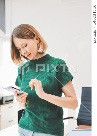 Closeup image of a businesswoman using mobile phone in office Closeup image of a businesswoman using mobile phone in office 140231516