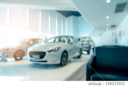 Blurred front view of white car and customer. New luxury car parked in modern showroom. Car dealership office. Electric car business concept. Automobile leasing. Showroom interior building design. Blurred front view of white car and customer. New luxury car parked in modern showroom. Car dealership office. Electric car business concept. Automobile leasing. Showroom interior building design. 140231952