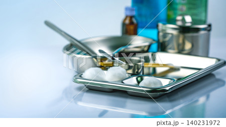 Wound care dressing set on stainless steel plate. White cotton ball, cotton stick, forceps, kidney basin, iodine cup, instruments container with cover or stainless steel cotton jar set. Medical tool. Wound care dressing set on stainless steel plate. White cotton ball, cotton stick, forceps, kidney basin, iodine cup, instruments container with cover or stainless steel cotton jar set. Medical tool. 140231972