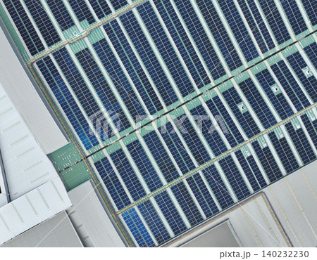 Solar energy system installed on the rooftop of an industrial factory and warehouse. Clean and renewable power solutions, green energy innovation, and sustainable commercial electricity generation. 140232230