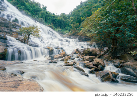 Beautiful waterfall with a lush green forest in the background. The water is flowing down the rocks and creating a beautiful scene. Sustainable waterfall in lush forest promoting water sustainability. 140232250