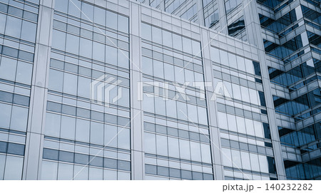 Skyscraper glass building of corporate headquarters in the downtown business area. Towering facade and windows embodying sleek, modern office environment. Financial institution. Modern architecture. Skyscraper glass building of corporate headquarters in the downtown business area. Towering facade and windows embodying sleek, modern office environment. Financial institution. Modern architecture. 140232282