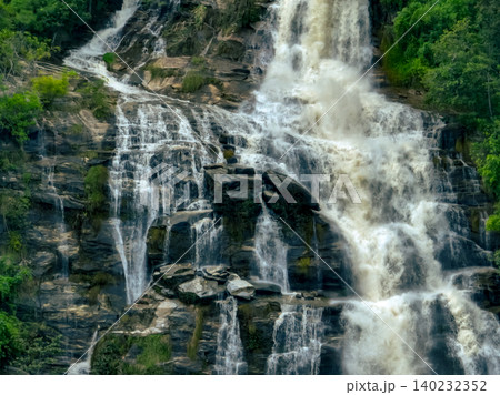 Aerial view of a waterfall in a lush tropical green forest in Doi Inthanon National Park, Chiang Mai, Thailand. This nature landscape showcases water sustainability and scenic travel destinations. Aerial view of a waterfall in a lush tropical green forest in Doi Inthanon National Park, Chiang Mai, Thailand. This nature landscape showcases water sustainability and scenic travel destinations. 140232352