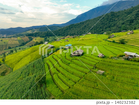 Landscape of green rice terraces and traditional huts in a village near Chiangmai, Thailand. Travel destinations. Beauty of terraced rice fields. Rural life and traditional farming practices in Asia. Landscape of green rice terraces and traditional huts in a village near Chiangmai, Thailand. Travel destinations. Beauty of terraced rice fields. Rural life and traditional farming practices in Asia. 140232382