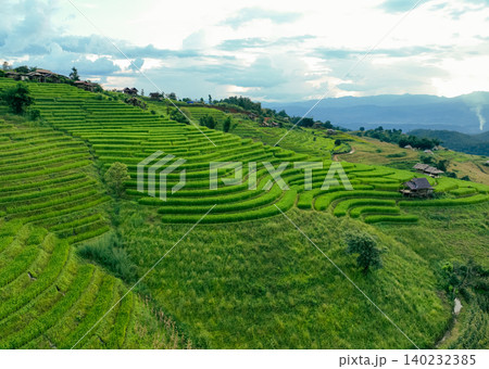 Landscape of green rice terraces and traditional huts in a village near Chiangmai, Thailand. Travel destinations. Beauty of terraced rice fields. Rural life and traditional farming practices in Asia. 140232385