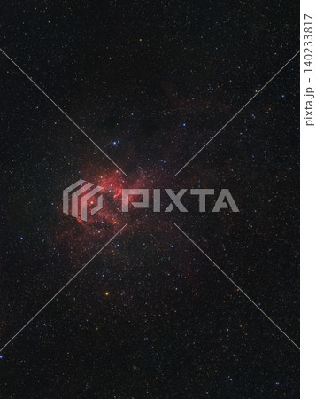 A vibrant red nebula, an emission cloud of ionized hydrogen, illuminates the dark expanse of space, surrounded by countless twinkling stars at night. A vibrant red nebula, an emission cloud of ionized hydrogen, illuminates the dark expanse of space, surrounded by countless twinkling stars at night. 140233817