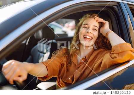 Emotional woman drives a car. The concept of fast movement, traveling by car. Emotional woman drives a car. The concept of fast movement, traveling by car. 140235139