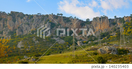 Scenic view of steep rocky mountains and green hills under a blue sky in Turkey 140235403