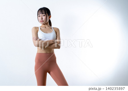 腕組みしてポージングする若い女性　鍛えてかっこいい筋トレ女子　自信　レギンス 140235897