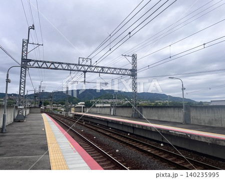 駅のホームから望む線路と奥に広がる山並みの風景 140235995